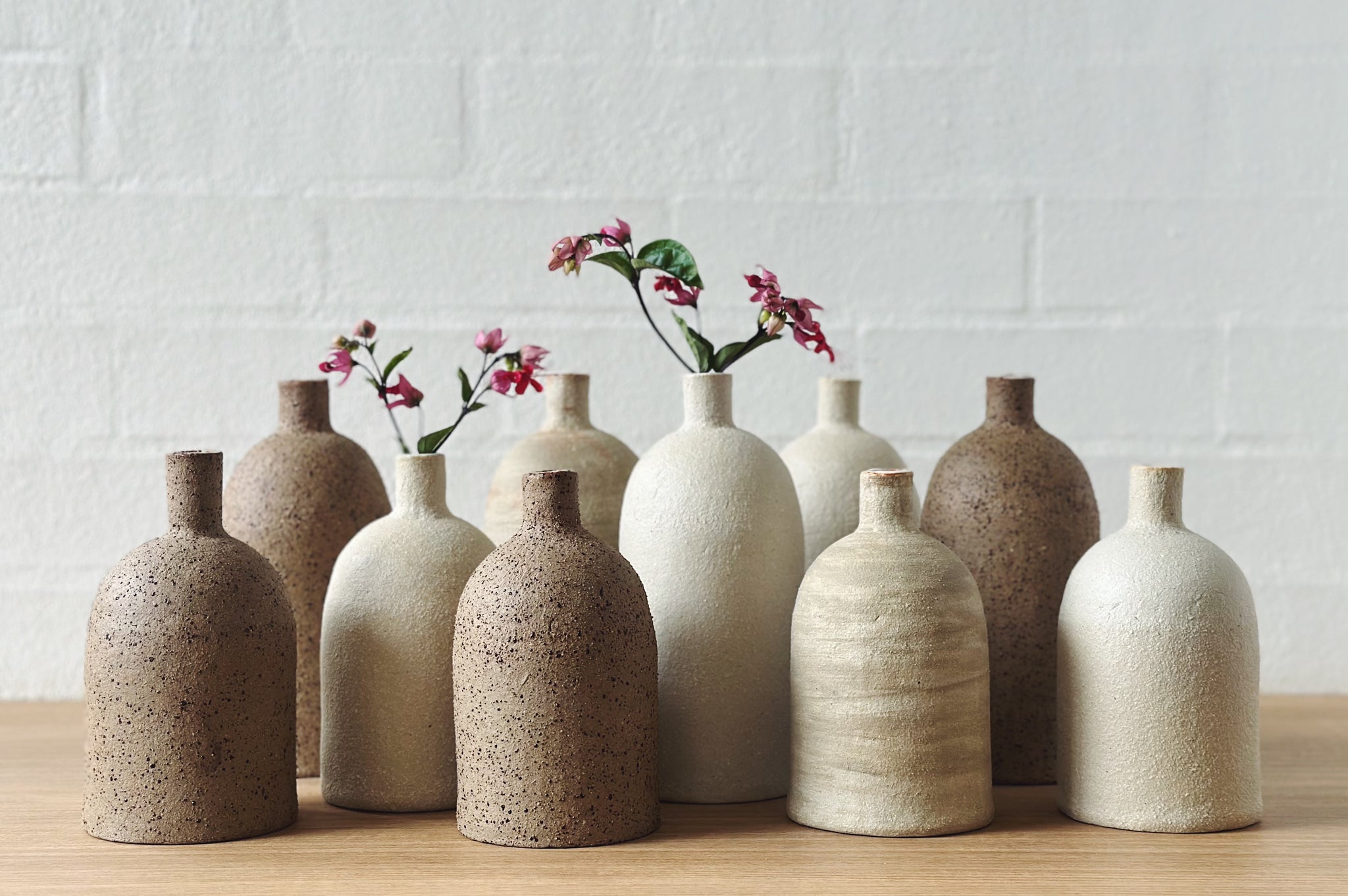 A collection of handmade ceramics bottles in earthy tones
