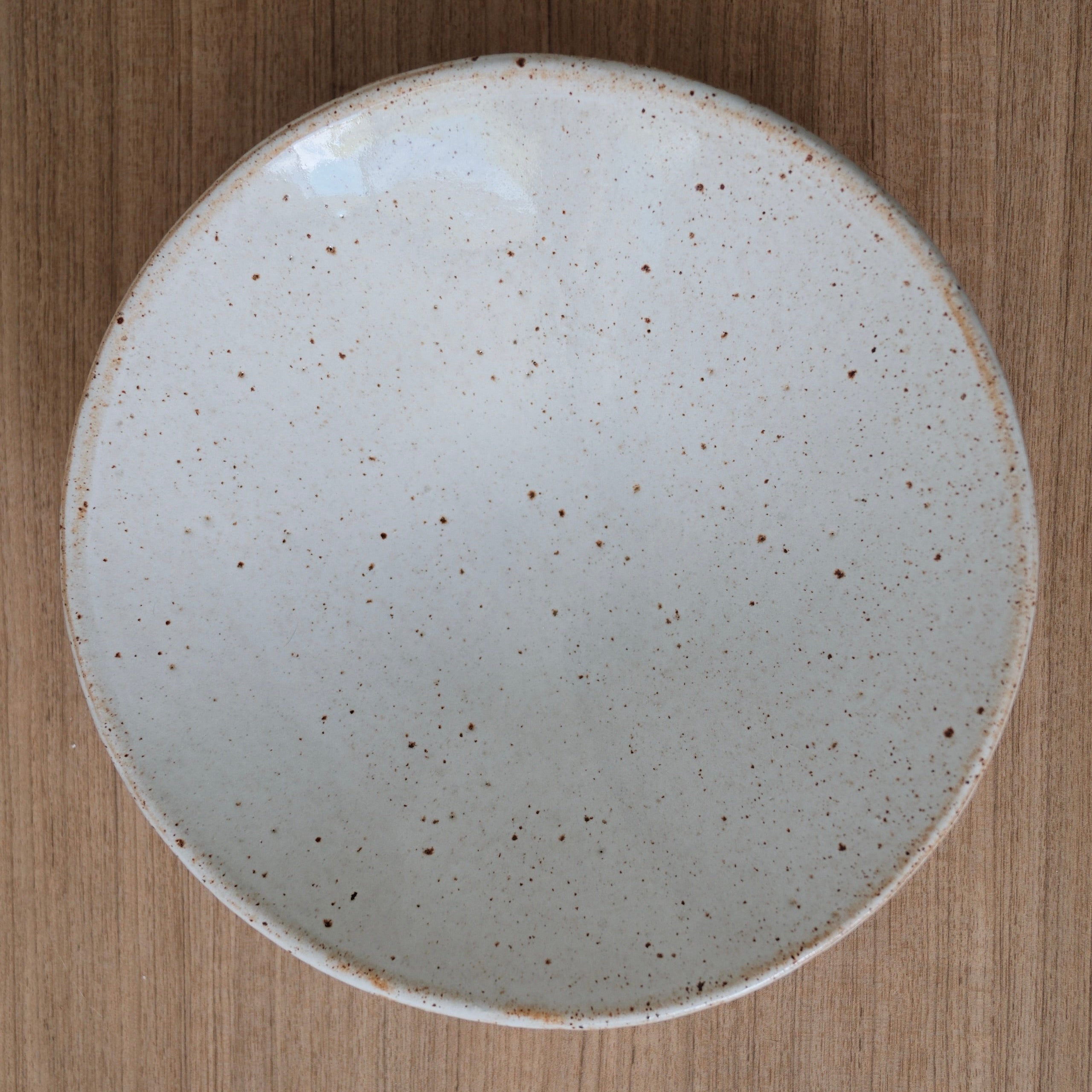Round ceramic bowl with speckled finish on a wooden surface