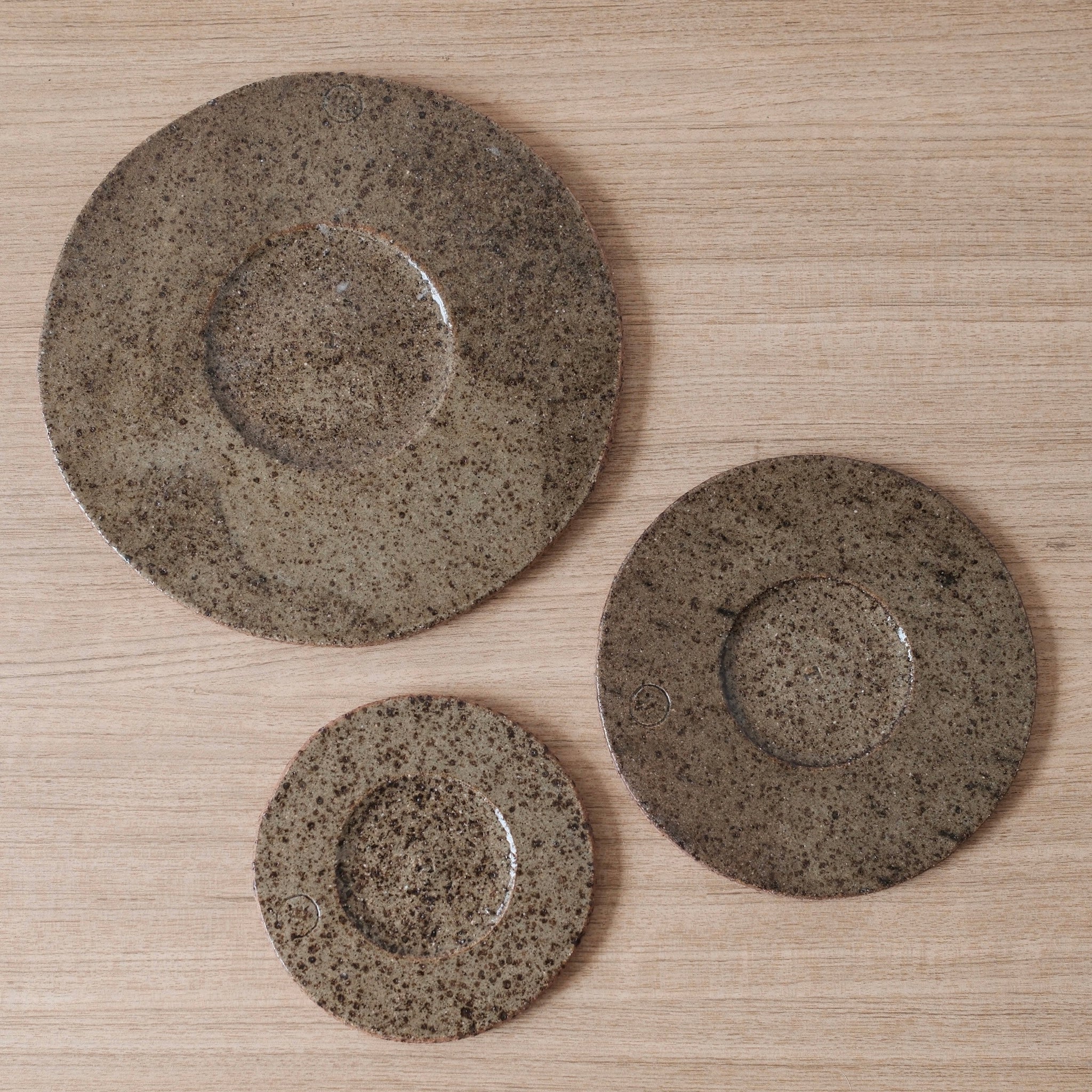 Birds-eye-view of three speckled brown ceramic drip trays