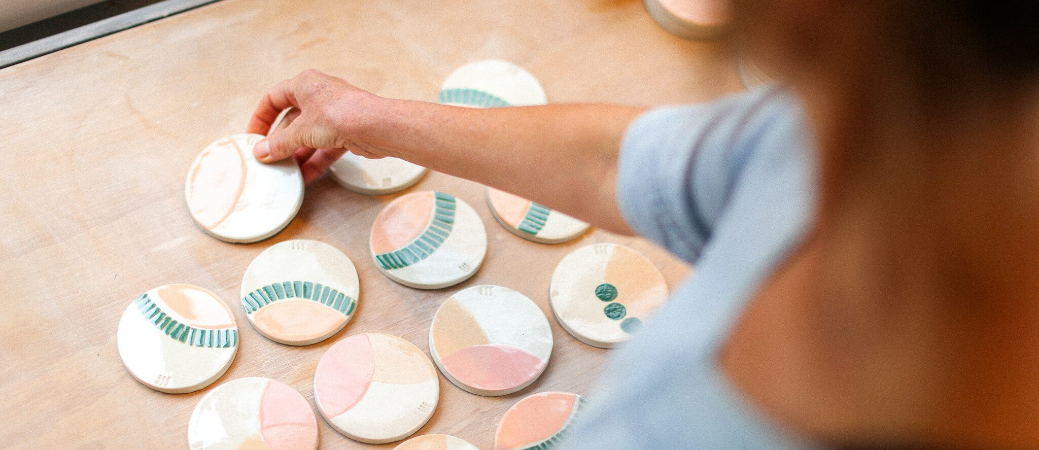 Jenn Johnston laying out the hand painted coasters she made for the Jenn Johnston Ceramics x Stone & Wood collaboration.& 